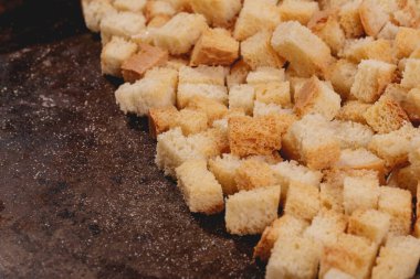 Pieces of roasted white bread in the baking tray. Close-up of delicious croutons.
