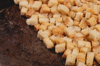Pieces of roasted white bread in the baking tray. Close-up of delicious croutons.