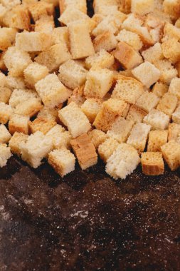 Pieces of roasted white bread in the baking tray. Close-up of delicious croutons.