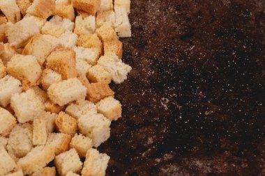 Pieces of roasted white bread in the baking tray. Close-up of delicious croutons.