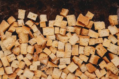 Pieces of roasted white bread in the baking tray. Close-up of delicious croutons. Top view