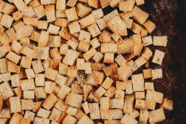 Pieces of roasted white bread in the baking tray. Close-up of delicious croutons. Top view