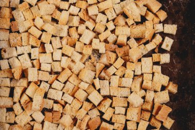 Pieces of roasted white bread in the baking tray. Close-up of delicious croutons. Top view