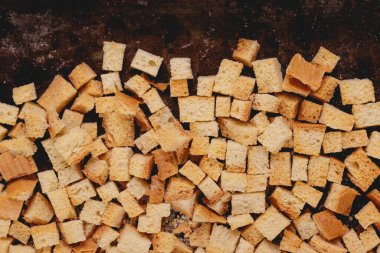 Pieces of roasted white bread in the baking tray. Close-up of delicious croutons. Top view