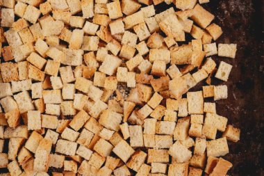 Pieces of roasted white bread in the baking tray. Close-up of delicious croutons. Top view