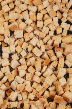 Pieces of roasted white bread on a dark background. Close-up of delicious croutons. Top view