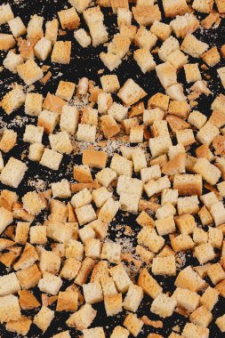 Pieces of roasted white bread on a dark background. Close-up of delicious croutons. Top view
