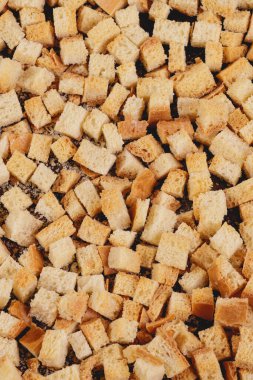 Pieces of roasted white bread on a dark background. Close-up of delicious croutons. Top view