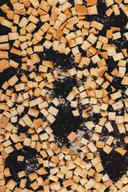 Pieces of roasted white bread on a dark background. Close-up of delicious croutons. Top view