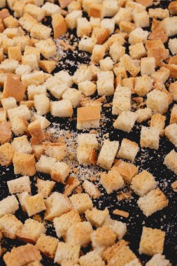 Koyu arkaplanda kavrulmuş beyaz ekmek parçaları. Lezzetli kızarmış ekmeklerin yakın çekimi..