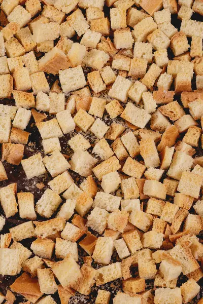 Pieces of roasted white bread on a dark background. Close-up of delicious croutons. Top view