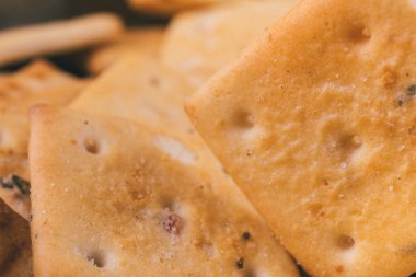 Lezzetli kare kraker yığını. Tuzlu krakerler yakın plan. Makro atış. Seçici odak.