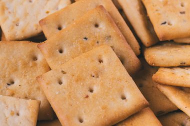 Lezzetli kare kraker yığını. Tuzlu krakerler yakın plan. Makro atış. Seçici odak.