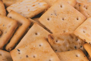 Lezzetli kare kraker yığını. Tuzlu krakerler yakın plan. Makro atış. Seçici odak.