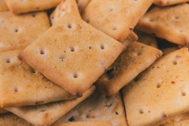 Lezzetli kare kraker yığını. Tuzlu krakerler yakın plan. Makro atış. Seçici odak.