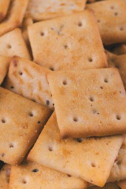 Lezzetli kare kraker yığını. Tuzlu krakerler yakın plan. Makro atış. Seçici odak.