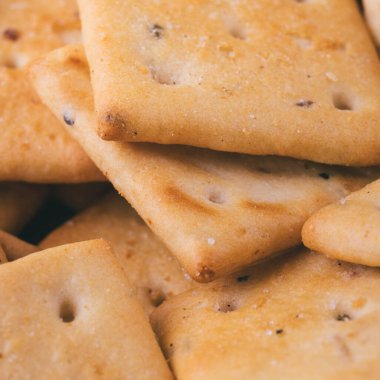 Lezzetli kare kraker yığını. Tuzlu krakerler yakın plan. Makro atış. Seçici odak.