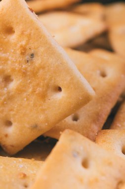 Lezzetli kare kraker yığını. Tuzlu krakerler yakın plan. Makro atış. Seçici odak.