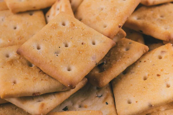 Lezzetli kare kraker yığını. Tuzlu krakerler yakın plan. Makro atış. Seçici odak.
