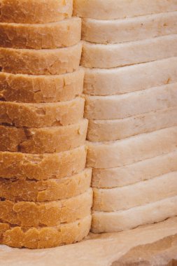 Kağıt üzerinde kahverengi kabuklu dilimlenmiş beyaz ekmek..