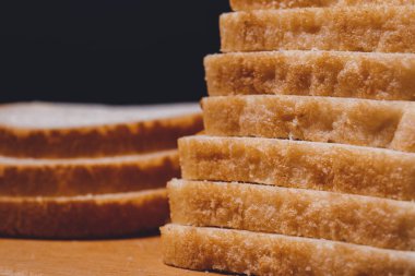 Dilimlenmiş beyaz ekmek, tahtanın üzerinde yakın plan kahverengi kabuklu..