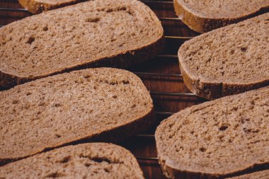 Koyu ahşap masadaki ızgarada dilimlenmiş kahverengi ekmek..