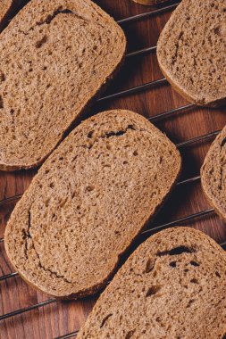 Koyu ahşap masadaki ızgara ızgarasında dilimlenmiş kahverengi ekmek. Üst görünüm