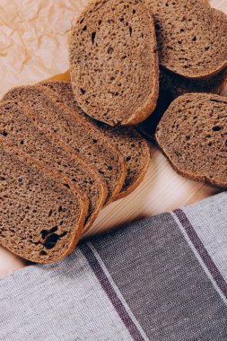 Beyaz ahşap masada dilimlenmiş kahverengi ekmek. Üst görünüm