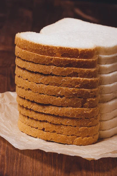Krájený Bílý Chléb Hnědou Krustou Pergamenovém Papíru Dřevěném Stole — Stock fotografie