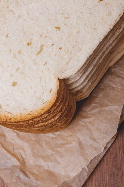 Sliced White Bread Brown Crust Closeup Parchment Paper Wooden Table — Stock Photo, Image