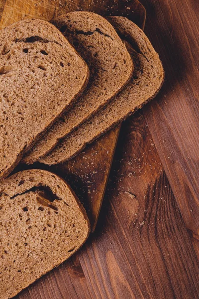 Brązowy Chleb Pokryty Otrębami Drewnianej Desce Ciemnym Drewnianym Stole Widok — Zdjęcie stockowe