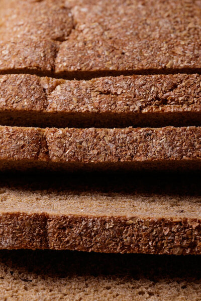 Sliced brown bread covered with bran closeup. Macro shot.
