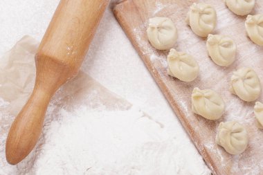 Tahtada hamur köftesi, masada un ve merdane. Ev yapımı hamur tatlısı. Üst görünüm.