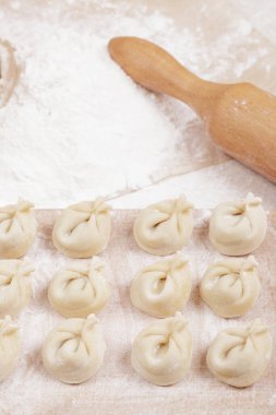 Tahtada hamur köftesi, masada un ve merdane. Ev yapımı hamur tatlısı yakın plan..