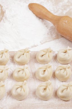 Tahtada hamur köftesi, masada un ve merdane. Ev yapımı hamur tatlısı yakın plan..