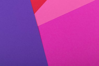 Farklı renklerde bir kağıdın çok renkli arkaplanı. Pembe, kırmızı ve mor renklerin karışımı. Geometrik arkaplan.