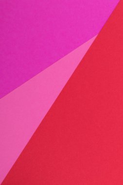 Farklı renklerde bir kağıdın çok renkli arkaplanı. Pembe, kırmızı ve mor renklerin karışımı. Geometrik arkaplan.