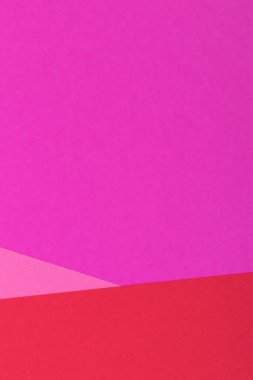 Farklı renklerde bir kağıdın çok renkli arkaplanı. Pembe, kırmızı ve mor renklerin karışımı. Geometrik arkaplan.
