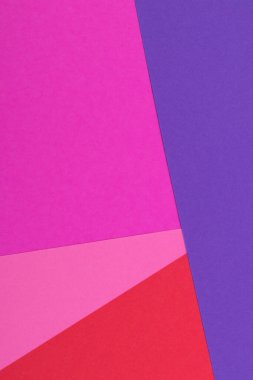 Farklı renklerde bir kağıdın çok renkli arkaplanı. Pembe, kırmızı ve mor renklerin karışımı. Geometrik arkaplan.