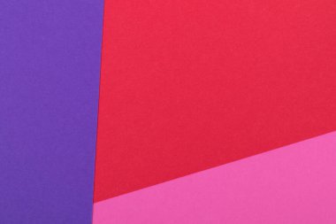 Farklı renklerde bir kağıdın çok renkli arkaplanı. Pembe, kırmızı ve mor renklerin karışımı. Geometrik arkaplan.