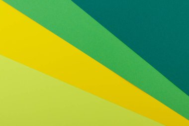 Farklı renklerde bir kağıdın çok renkli arkaplanı. Sarı, yeşil, koyu yeşil ve limon renklerinin karışımı. Geometrik arkaplan.