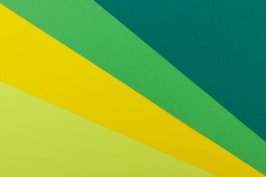 Farklı renklerde bir kağıdın çok renkli arkaplanı. Sarı, yeşil, koyu yeşil ve limon renklerinin karışımı. Geometrik arkaplan.