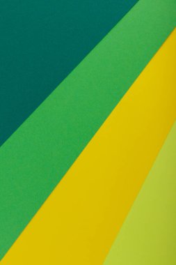 Farklı renklerde bir kağıdın çok renkli arkaplanı. Sarı, yeşil, koyu yeşil ve limon renklerinin karışımı. Geometrik arkaplan.