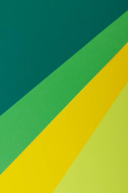 Farklı renklerde bir kağıdın çok renkli arkaplanı. Sarı, yeşil, koyu yeşil ve limon renklerinin karışımı. Geometrik arkaplan.