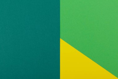 Farklı renklerde bir kağıdın çok renkli arkaplanı. Sarı, yeşil ve koyu yeşil renklerin karışımı. Geometrik arkaplan.