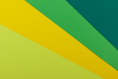 Farklı renklerde bir kağıdın çok renkli arkaplanı. Sarı, yeşil, koyu yeşil ve limon renklerinin karışımı. Geometrik arkaplan.