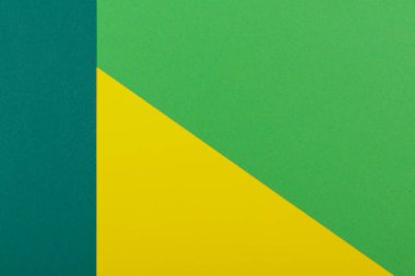 Farklı renklerde bir kağıdın çok renkli arkaplanı. Sarı, yeşil ve koyu yeşil renklerin karışımı. Geometrik arkaplan.