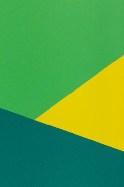 Farklı renklerde bir kağıdın çok renkli arkaplanı. Sarı, yeşil ve koyu yeşil renklerin karışımı. Geometrik arkaplan.