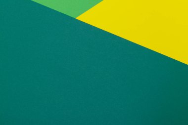 Farklı renklerde bir kağıdın çok renkli arkaplanı. Sarı, yeşil ve koyu yeşil renklerin karışımı. Geometrik arkaplan.