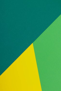 Farklı renklerde bir kağıdın çok renkli arkaplanı. Sarı, yeşil ve koyu yeşil renklerin karışımı. Geometrik arkaplan.